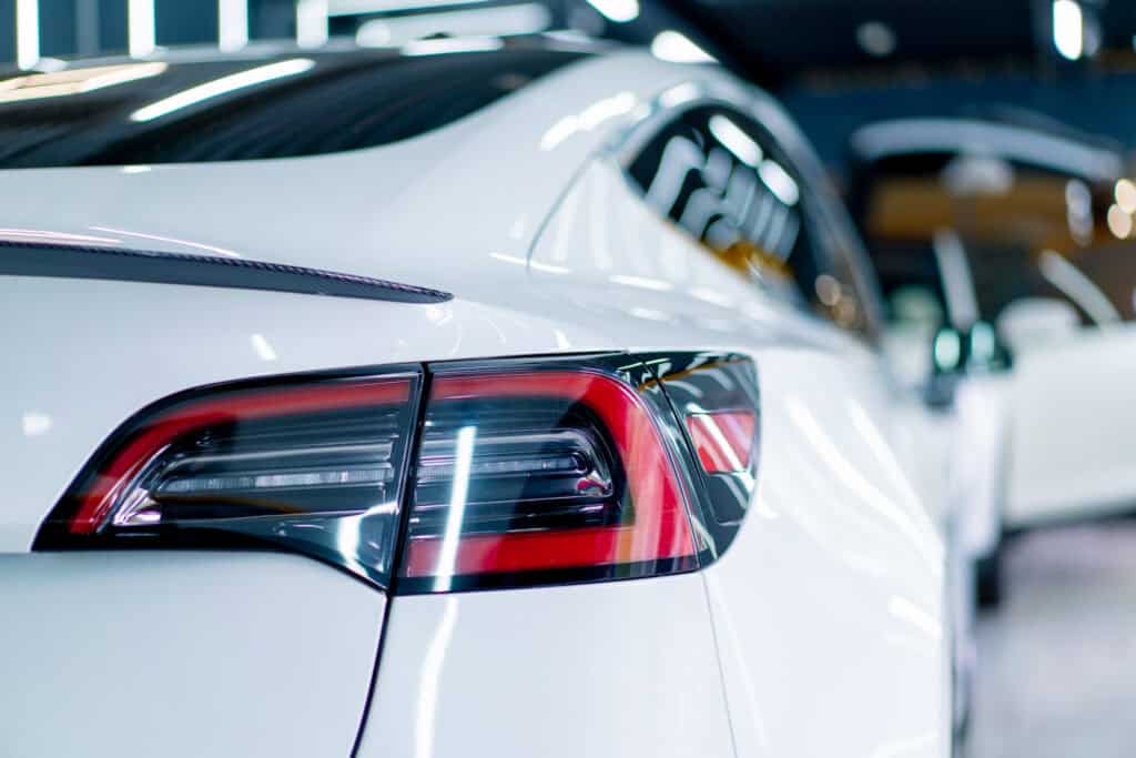 White vehicle rear taillight and polished paint finish after exterior detailing service at Symtek Automotive.