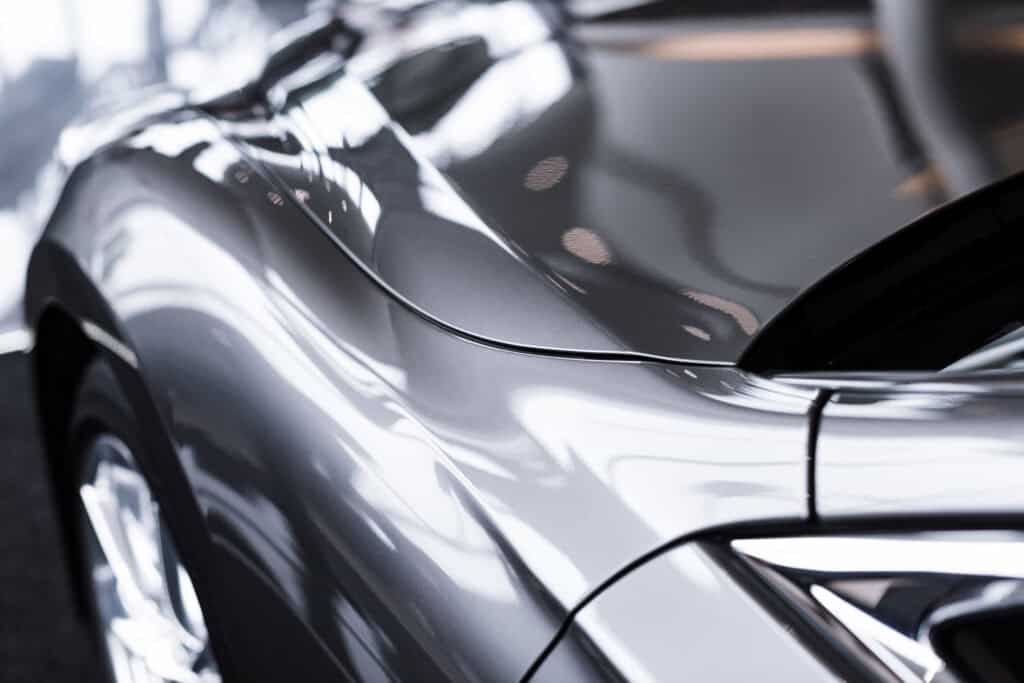 Glossy gray vehicle hood and side panel after paint correction and exterior detailing service at Symtek Automotive.