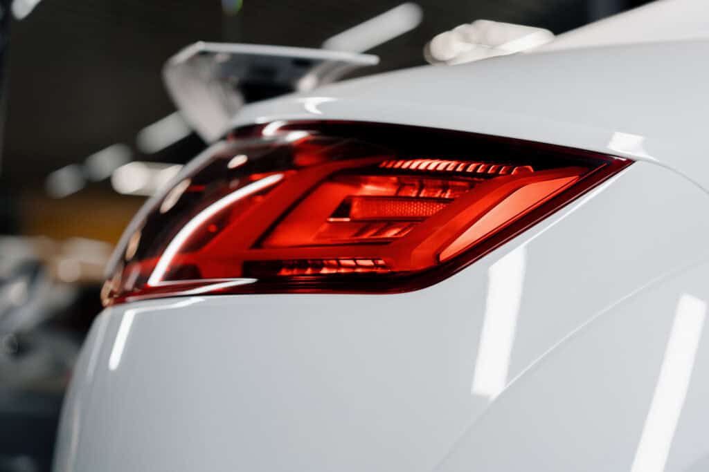 White sports car rear taillight and glossy paint finish after auto detailing service at Symtek Automotive.