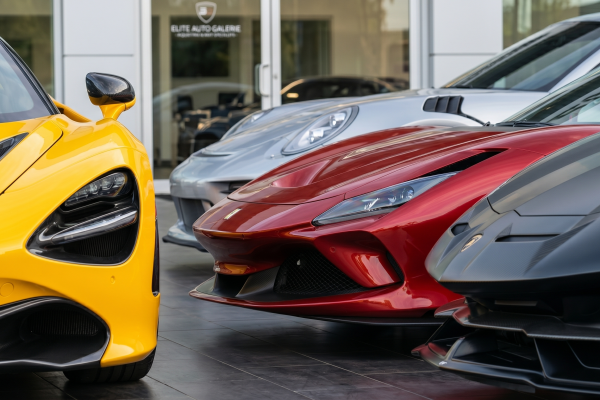 Luxury sports cars lined up outside a service facility for paintless dent repair and hail damage repair by Symtek Automotive.