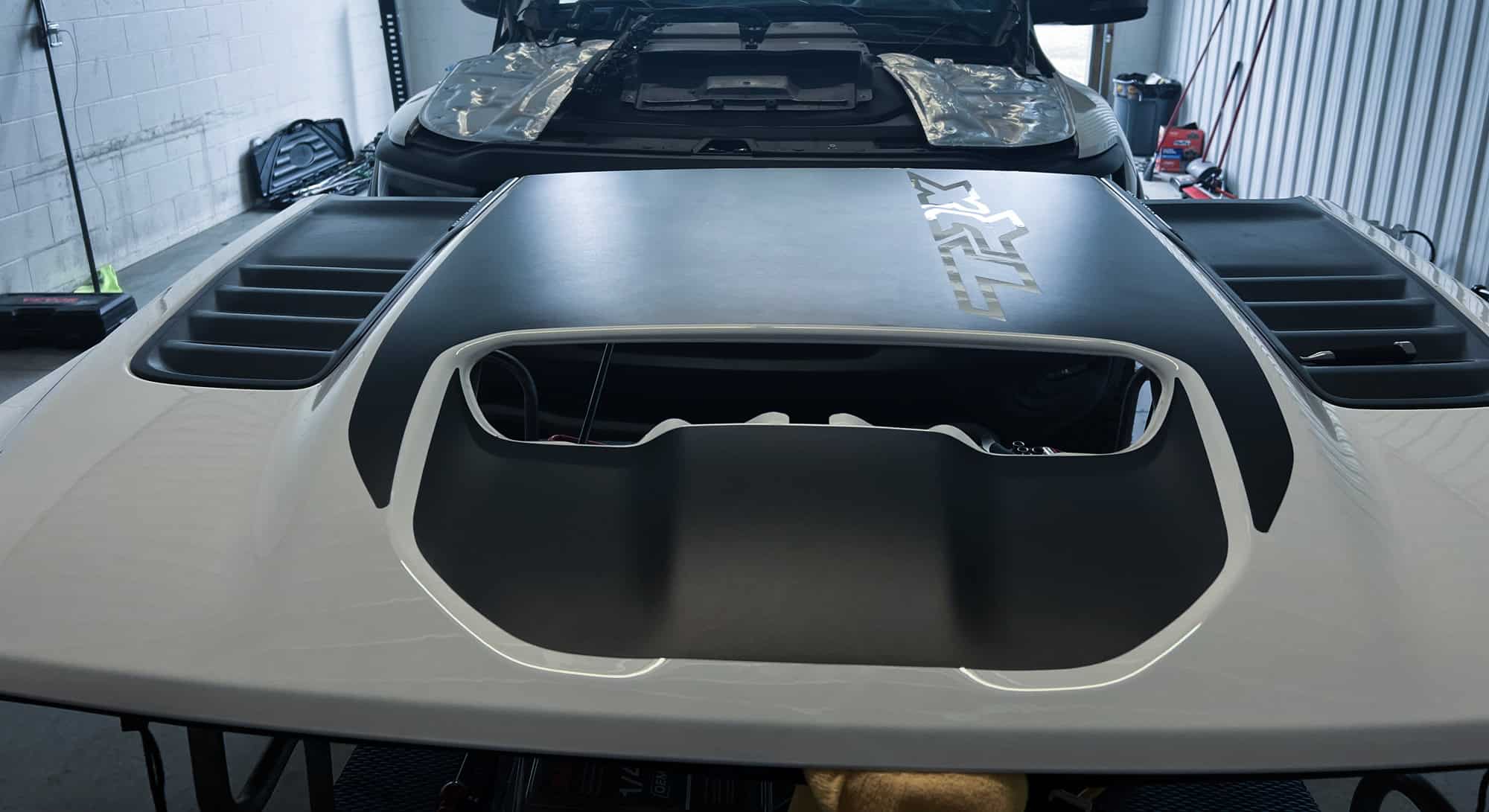 White vehicle roof panel inside Symtek Automotive shop after paintless dent repair and hail damage inspection by Symtek in Canton, Ohio.