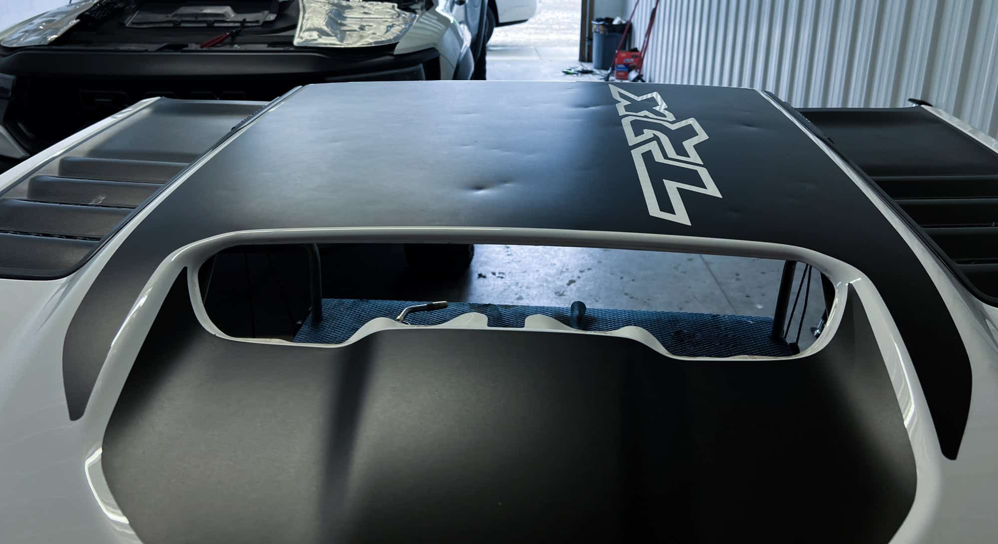 White vehicle roof with visible dent damage before paintless dent repair at Symtek Automotive in Canton, Ohio.